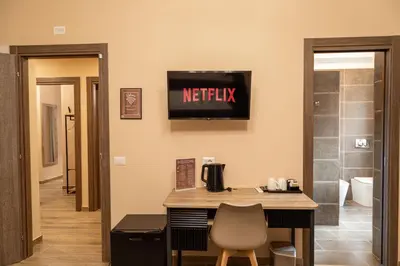 a room with a desk and a tv on the wall at Diamond Vatican Apartment in Rome
