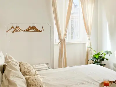 a bedroom with a white bed with a mirror at Grazioso appartamento al Pigneto in Rome