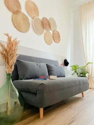 a couch in a living room with a vase at Grazioso appartamento al Pigneto in Rome