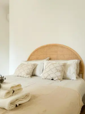 a bed with white pillows and a wooden headboard at Grazioso appartamento al Pigneto in Rome