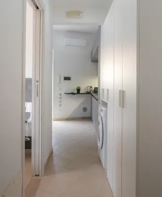 a white kitchen with a washer and dryer at VivimiHome - Holiday Life Rome in Rome
