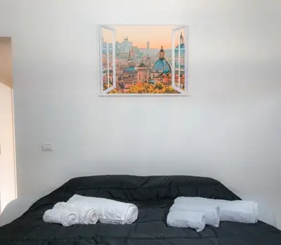 a bed with two towels and a picture on the wall at VivimiHome - Holiday Life Rome in Rome
