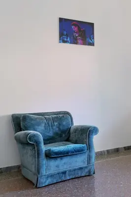 a blue chair sitting next to a white wall at Villa Fiorelli rooms in Rome