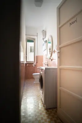a bathroom with a washing machine and a toilet at Villa Fiorelli rooms in Rome