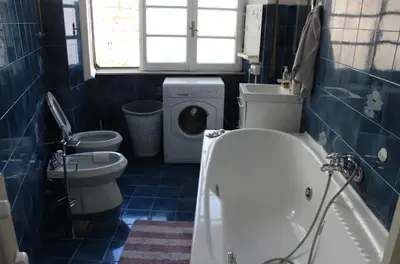 a bathroom with a tub and a toilet and a washing machine at Appartamento 5 stelle in Piazza Asti - Re di Roma - in Rome