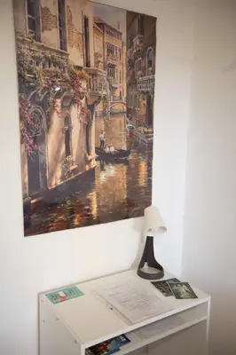 a painting on a wall next to a desk with a lamp at Stanza da Apollo e Diana in Rome