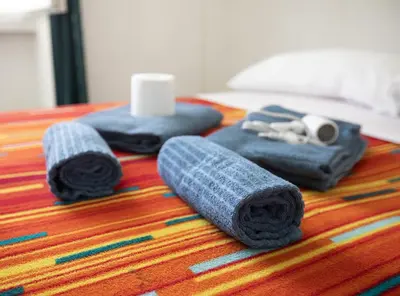 a table with three rolled towels on a table at Stanza da Apollo e Diana in Rome