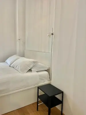 a white bed with a black table next to it at Civitas Leonina Apartment in Rome