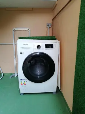 a washing machine in a room with a green floor at San Pietro Happy Home in Rome