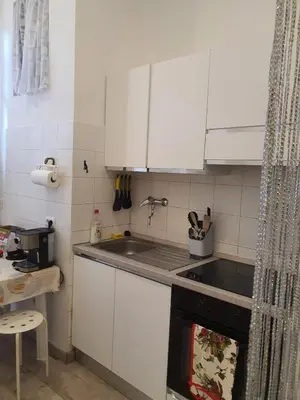 a kitchen with white cabinets and a stove top oven at Casa Max in Rome