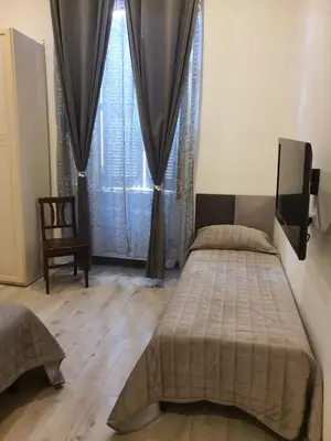 a bedroom with two beds and a tv and a window at Casa Max in Rome