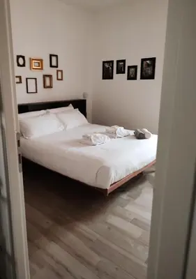 a bed in a bedroom with pictures on the wall at Bagnera51 in Rome