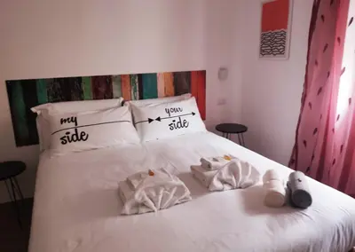 a bedroom with a bed with white sheets and pillows at Bagnera51 in Rome