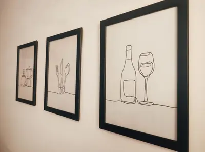 three framed drawings of a wine bottle and a glass at Bagnera51 in Rome