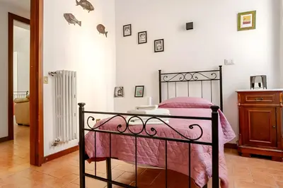 a bedroom with a bed with a pink comforter at Rome artist house in Rome