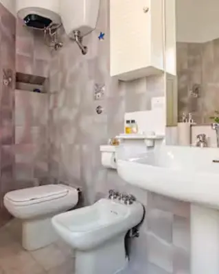 a bathroom with a white toilet and a sink at Rome artist house in Rome