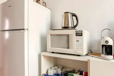 a microwave sitting on a shelf next to a refrigerator at Rome artist house in Rome