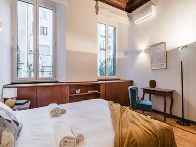 a bedroom with a bed and a desk and two windows at The Best Rent - Three-Bedroom apartment in Manzoni district in Rome