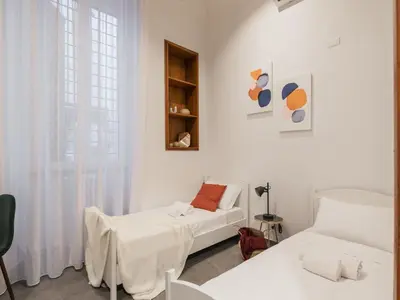 a white room with two beds and a window at The Best Rent - Three-Bedroom apartment in Manzoni district in Rome