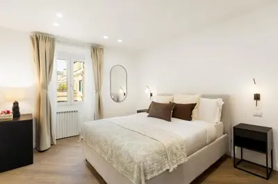 a white bedroom with a large bed and a mirror at Terrace Boutique Apartment - Dolce Vita in Rome