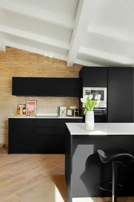 a kitchen with black cabinets and a white counter at Terrace Boutique Apartment - Dolce Vita in Rome