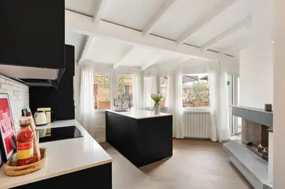 a kitchen with black cabinets and a white counter top at Terrace Boutique Apartment - Dolce Vita in Rome