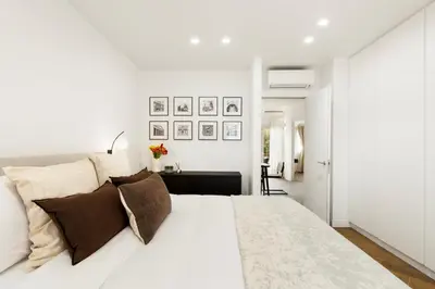 a white bedroom with a large white bed with pillows at Terrace Boutique Apartment - Dolce Vita in Rome