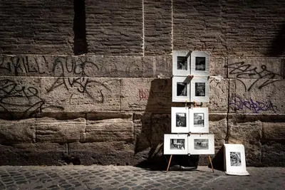 a group of pictures on display in front of a wall at Lungaretta Studio Flat [trastevere] in Rome