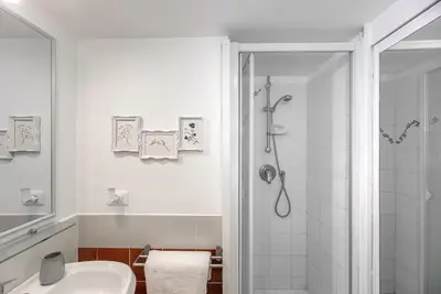 a white bathroom with a shower and a sink at Lungaretta Studio Flat [trastevere] in Rome