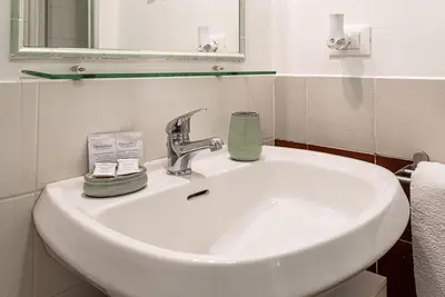 a white sink in a bathroom with a mirror at Lungaretta Studio Flat [trastevere] in Rome