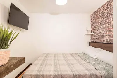 a bedroom with a bed and a brick wall at Lungaretta Studio Flat II (Trastevere) in Rome