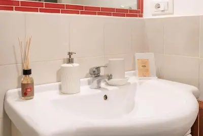a white bathroom sink with a soap dispenser on it at Lungaretta Studio Flat II (Trastevere) in Rome