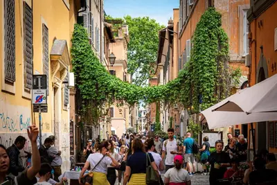 a crowd of people walking down a narrow street at Lungaretta Studio Flat II (Trastevere) in Rome