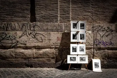 a group of pictures on display in front of a wall at Lungaretta Studio Flat II (Trastevere) in Rome
