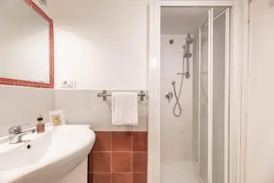 a white bathroom with a sink and a shower at Lungaretta Studio Flat II (Trastevere) in Rome