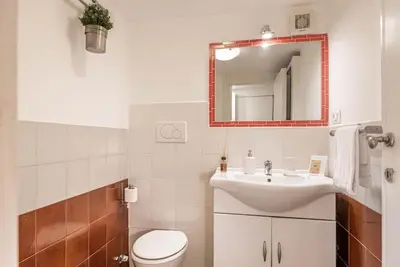 a bathroom with a sink and a toilet and a mirror at Lungaretta Studio Flat II (Trastevere) in Rome
