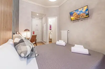 a bedroom with a bed and a television on the wall at Maison Macao - Golden Keys Collection in Rome