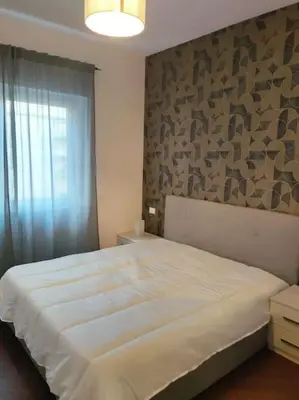 a bedroom with a large white bed with a stone wall at Il covo dei Briganti in Rome