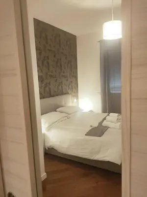 a bedroom with a white bed with a wall at Il covo dei Briganti in Rome