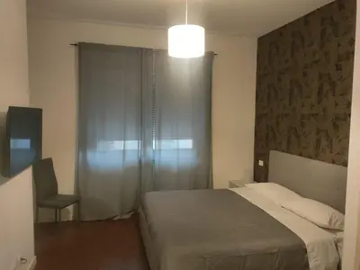 a bedroom with a bed and a chair and a window at Il covo dei Briganti in Rome
