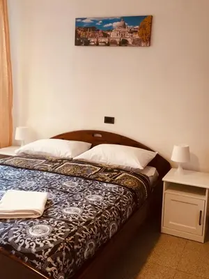 a bed in a bedroom with a picture on the wall at San Giovanni Apartment in Rome