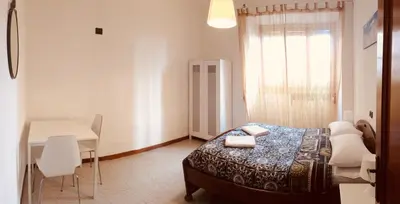 a bedroom with a bed and a table and a desk at San Giovanni Apartment in Rome