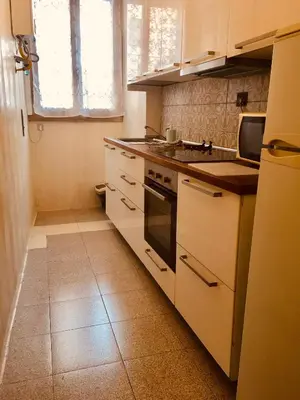 a kitchen with white cabinets and a stove top oven at San Giovanni Apartment in Rome