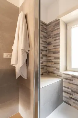 a bathroom with a shower with a towel hanging on the wall at Marisa Home in Rome