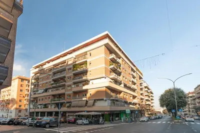 a tall building with cars parked on a street at Marisa Home in Rome