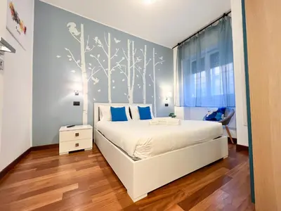 a bedroom with a white bed with blue pillows at UNIQUE House - 3 Bedrooms & 2 Bathrooms with 4 Beds - 100 meters to the Metro A in Rome