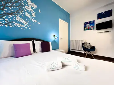 a bedroom with a white bed with a blue wall at UNIQUE House - 3 Bedrooms & 2 Bathrooms with 4 Beds - 100 meters to the Metro A in Rome