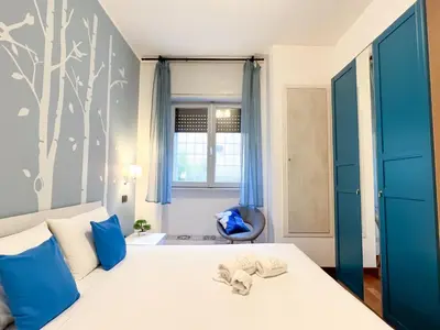a bedroom with a bed with blue pillows at UNIQUE House - 3 Bedrooms & 2 Bathrooms with 4 Beds - 100 meters to the Metro A in Rome