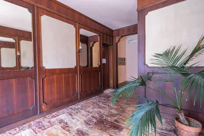 a hallway with wooden doors and a potted plant at Garden House by BuddyRent in Rome