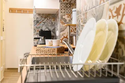 a dishwasher in a kitchen with white dishes at Vatican Bells with Balcony View of St Peters Dome Two Bedrooms Two Bathrooms in Rome